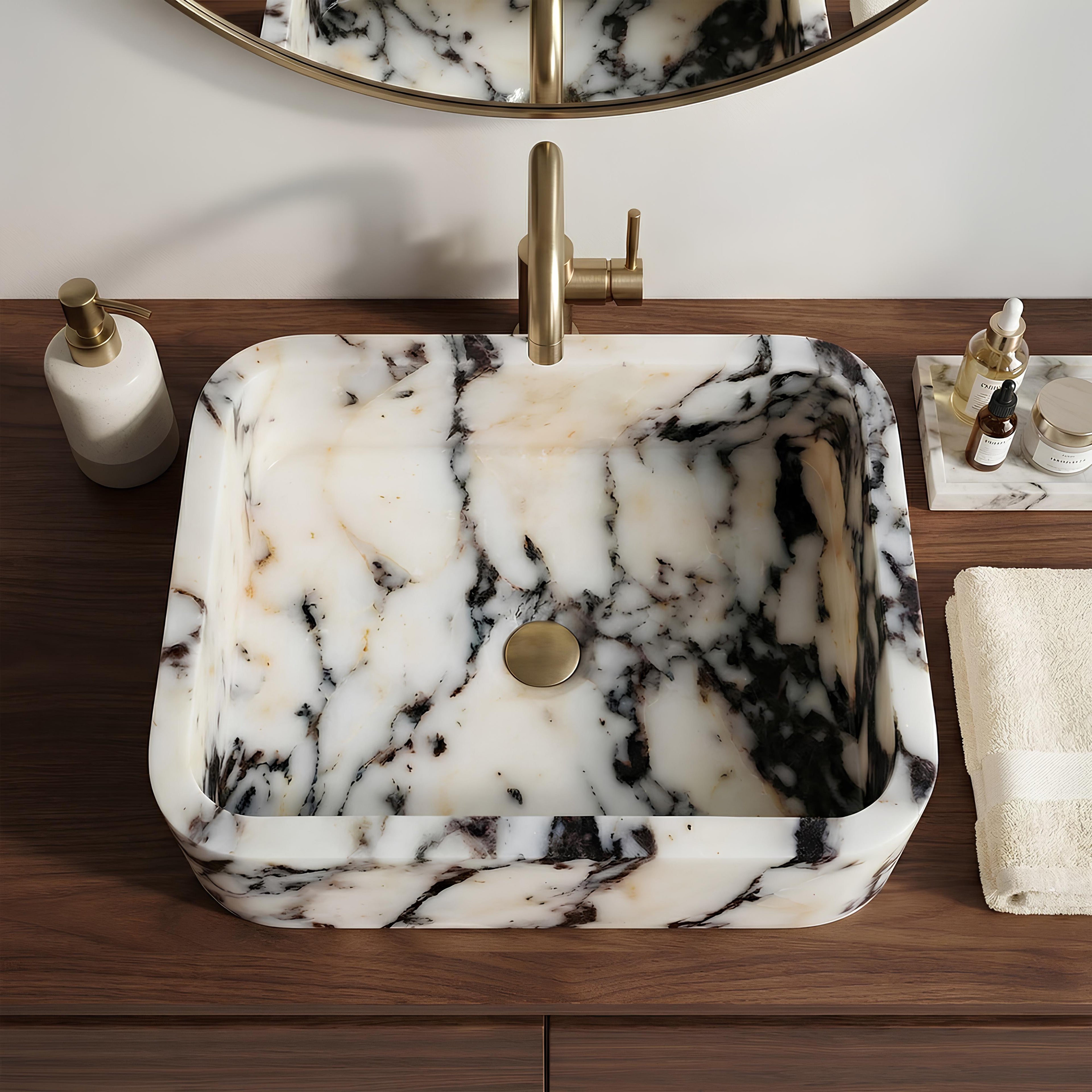 Marble-patterned sink with gold faucet on a wooden vanity