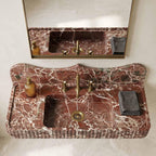 Marble sink with gold fixtures and a mirror in a bathroom setting
