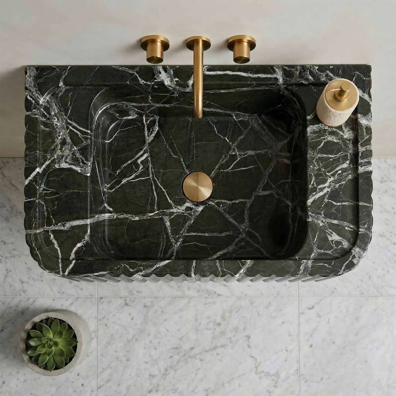 Marble sink with gold fixtures on a white countertop