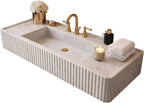 Marble sink with gold faucet, candles, and towels on a white background