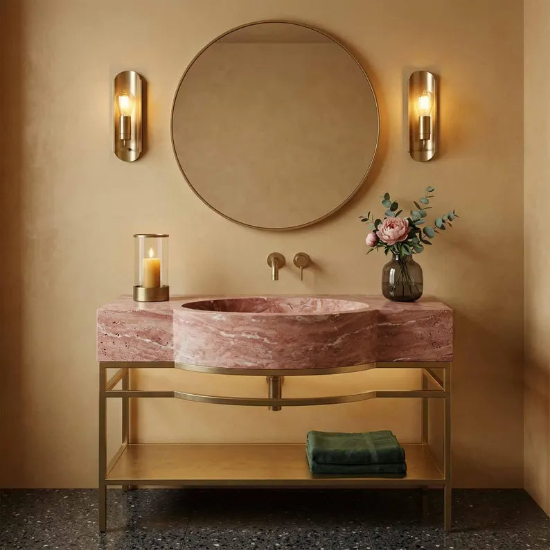 Bathroom vanity with pink marble sink, round mirror, and decorative elements.