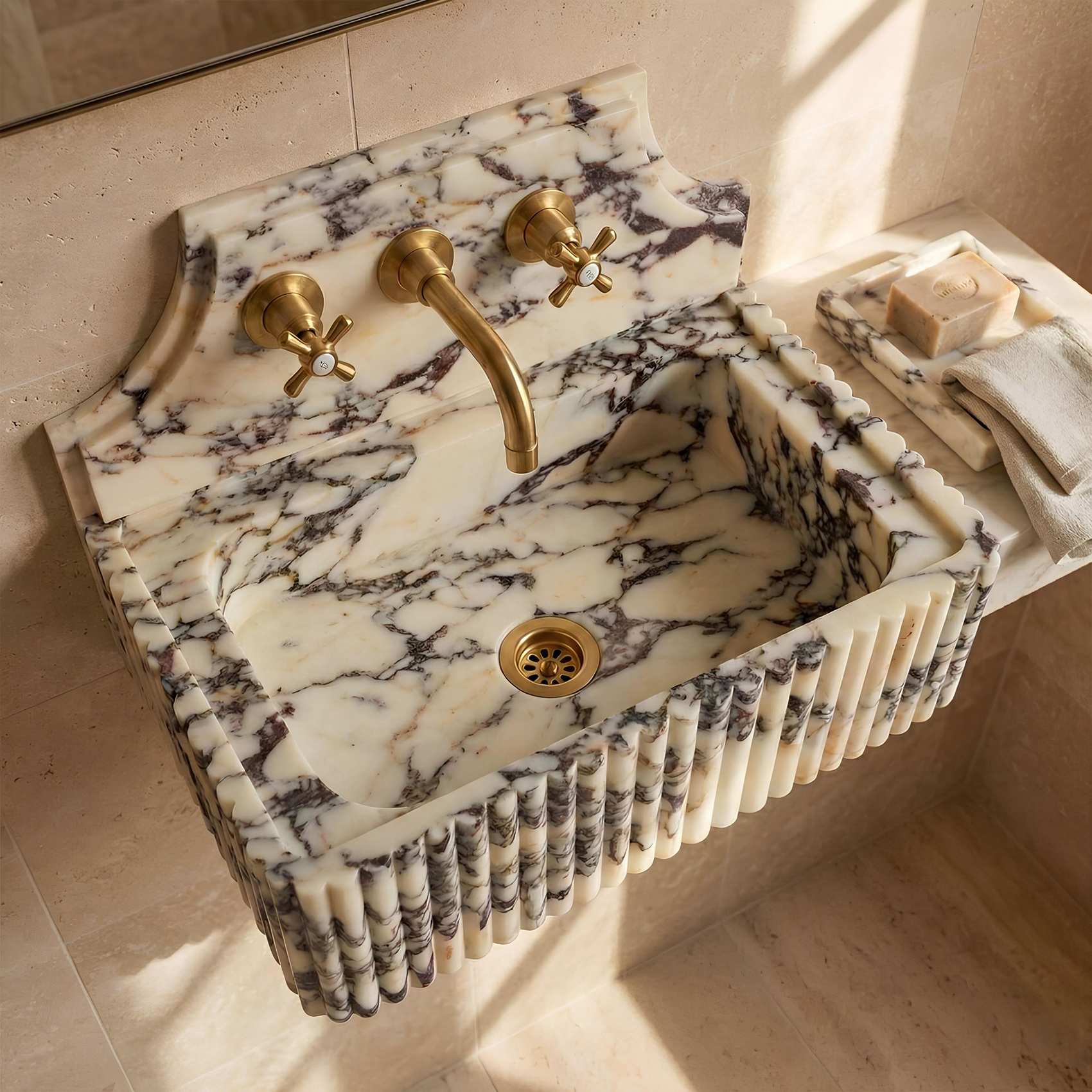 Marble sink with gold fixtures in a bathroom setting